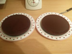 Both halves of the cakes without pans sitting on plates