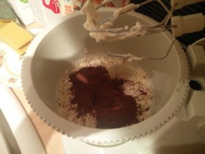 The cocoa powder has been put into the mixing bowl with the remaining whipping cream