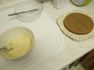 The icing in the bowl and a cake half near it