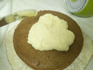 The icing has been dolloped onto the top of the cake