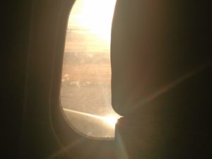 The sun rising and reflecting off the wing of the plane